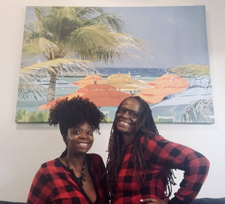 Our family in matching red plaid pajamas, smiling at home